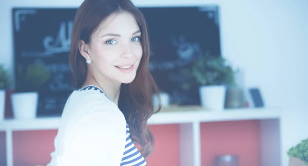 Young woman standing near desk in the kitchen — Stock Photo, Image