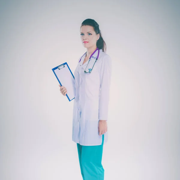 Smiling female doctor with a folder in uniform standing at hospital — Stock Photo, Image