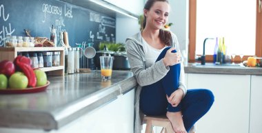 Mutfakta masada oturan genç bir kadın. .