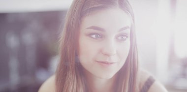 Güzel bir kadın mutfakta pasta pişiriyor. Masanın yanında duruyor.