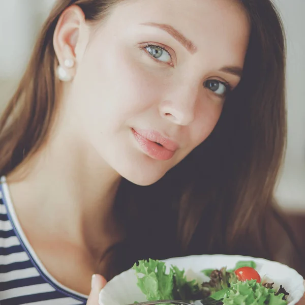 Giovane donna mangiare insalata e tenere un'insalata mista — Foto Stock