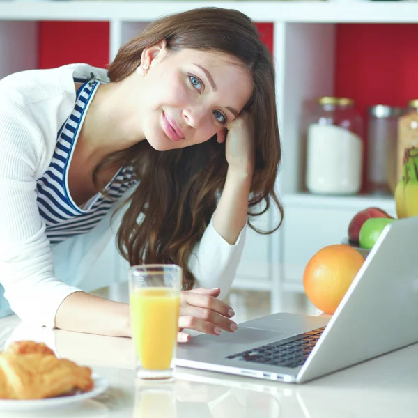 Jeune femme assise près du bureau dans la cuisine — Photo