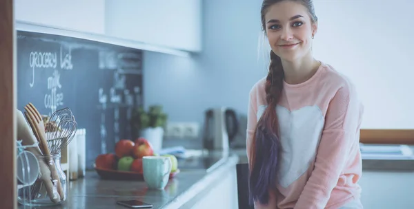 Young woman sitting near table in the kitchen — Stock Photo, Image