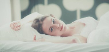 Güzel bir kadın yatağında uzanıyor.