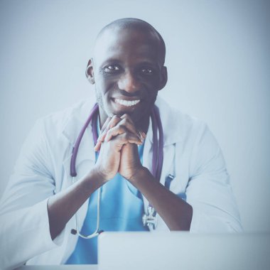 Masada dizüstü bilgisayarda çalışan genç bir Afrikalı doktor.