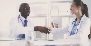 Ofiste tokalaşırken gülümseyen iki genç doktor.