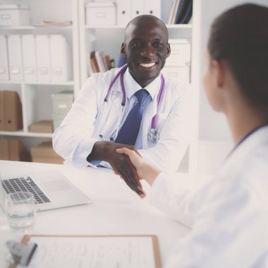 Ofiste tokalaşırken gülümseyen iki genç doktor.