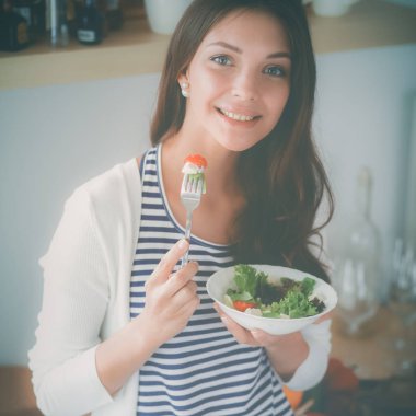 Genç bayan mutfakta masanın yanında oturuyor.