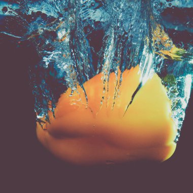 Taze su siyah zemin üzerine sarı kırmızı biber sıçrama