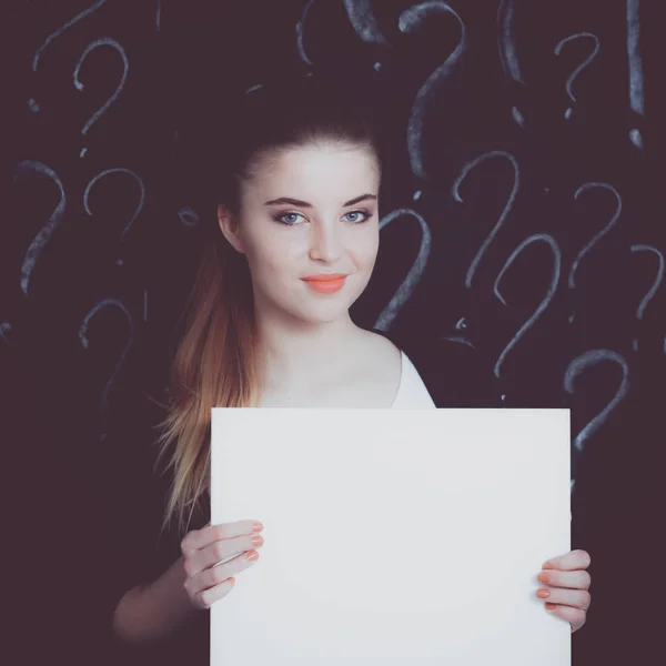 Young girl with question mark on a gray background — Stock Photo, Image