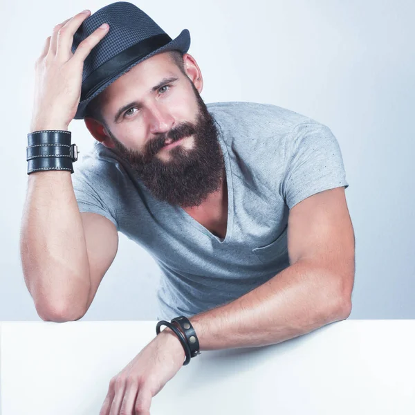 Portrait of young man in hat standing near blank, isolated on white background — Stock Photo, Image