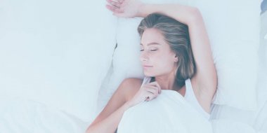 Güzel bir kadın yatağında uzanıyor.
