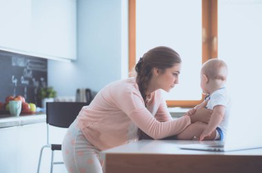 Annesi bebeğini evde parlak mutfakta ile