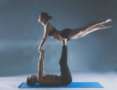 Genç çift Acro yoga mat Studio birlikte uygulamak