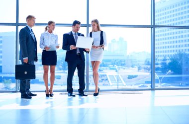 Toplantı sırasında dizüstü bilgisayarla sunum yapan bir grup iş adamı