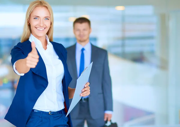 Portrait of young businesswoman in office with colleagues in the background — Stock Photo, Image