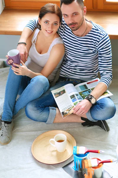 Casal em movimento em casa sentado no chão — Fotografia de Stock