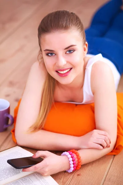 Lächelnde junge Frau liegt mit Kopfkissen auf dem Boden — Stockfoto