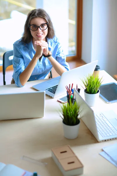 Giovane donna seduta al tavolo dell'ufficio con computer portatile — Foto Stock