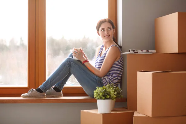 Flickan sitter på fönsterkarm nya hemma med kopp — Stockfoto