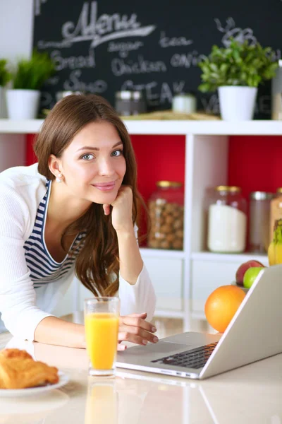 Young woman sitting near desk in the kitchen — Stock Photo, Image