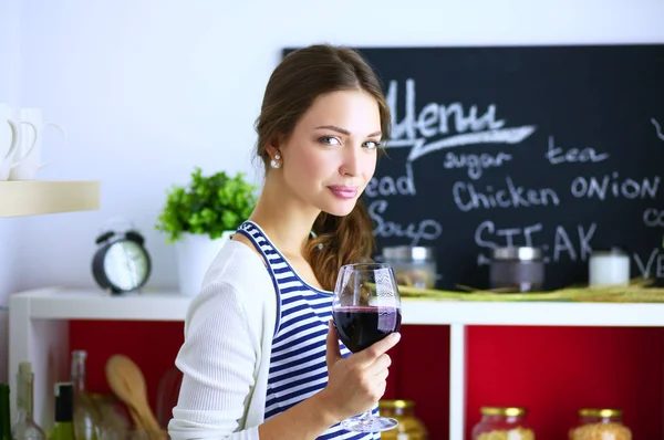 Hübsche Frau trinkt zu Hause Wein in Küche — Stockfoto