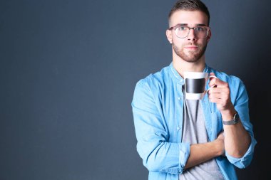 Ayakta ve elinde fincan kahve onun elinde portre yakışıklı genç adam