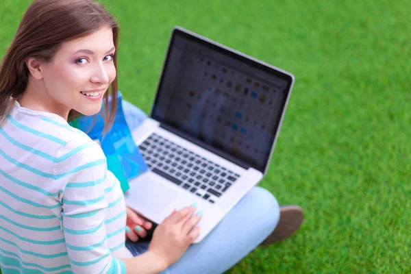 Mujer joven con portátil sentado en la hierba verde —  Fotos de Stock