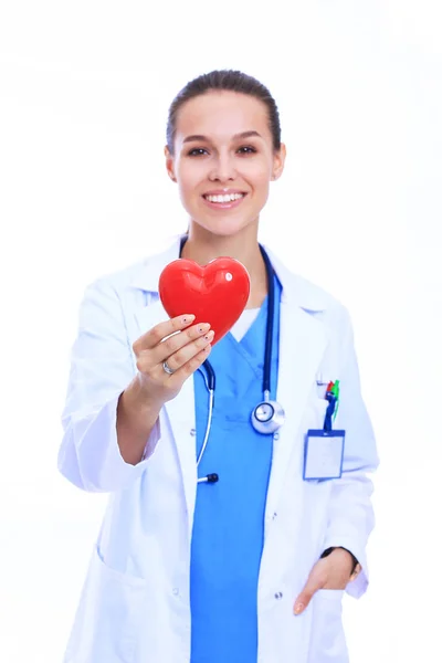 Médica feminina positiva em pé com estetoscópio e símbolo de coração vermelho — Fotografia de Stock