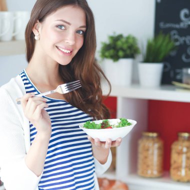 Salata yemek ve karışık salata tutan genç kadın