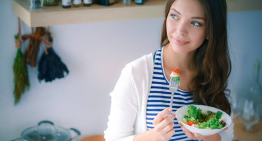 Salata yemek ve karışık salata tutan genç kadın
