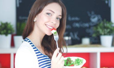 Salata yemek ve karışık salata tutan genç kadın