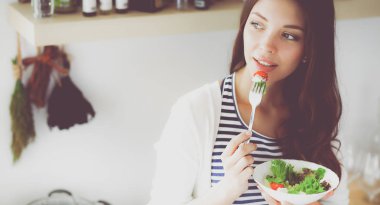 Salata yemek ve karışık salata tutan genç kadın