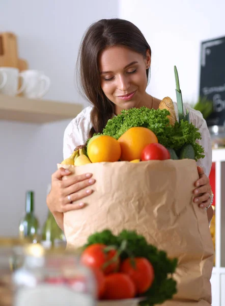 Jonge vrouw met grocery shopping bag met groenten en fruit — Stockfoto