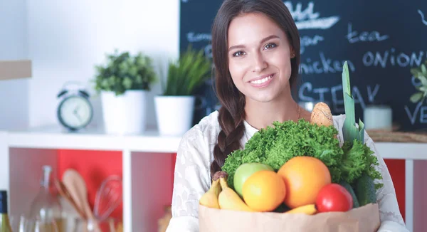 Young woman holding grocery shopping bag with vegetables — Stock Photo, Image