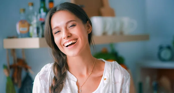 Jonge vrouw in de buurt van bureau in de keuken — Stockfoto