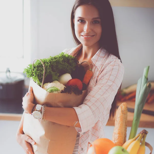 Jeune femme tenant sac d'épicerie avec des légumes — Photo