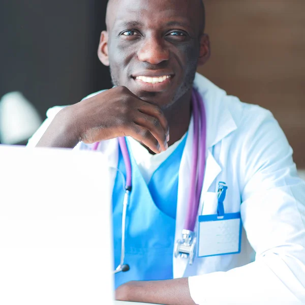 Masada dizüstü bilgisayarda çalışan genç bir Afrikalı doktor. — Stok fotoğraf