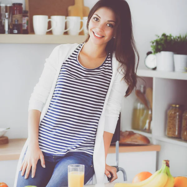 Potret seorang wanita cantik duduk di dapur — Stok Foto