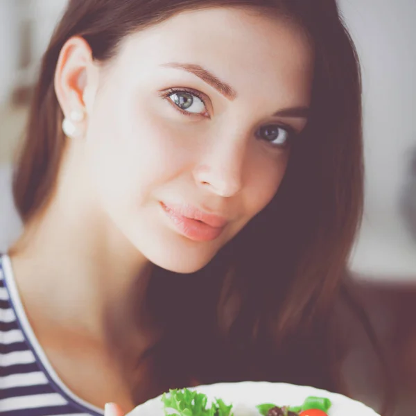 Giovane donna mangiare insalata e tenere un'insalata mista — Foto Stock