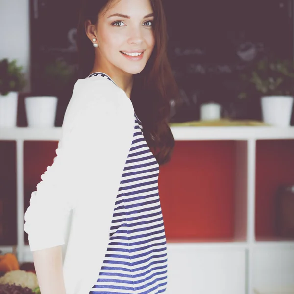 Young woman standing in kitchen at home