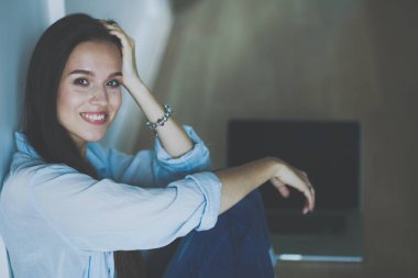 Yatakta çocuk karyolası yakın oturan genç kadın