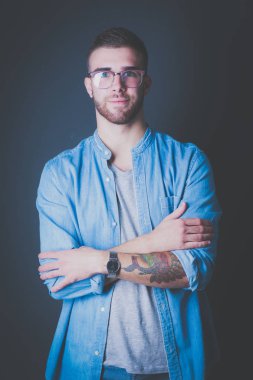 Mutlu bir casual adam ayakta karanlık bir arka plan üzerinde izole portresi