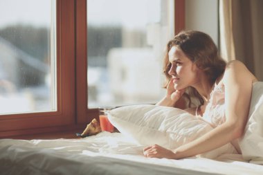 Güzel bir kadın yatağında uzanıyor.