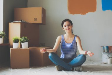 Karton kutuları olan yeni bir evde bir kadın.