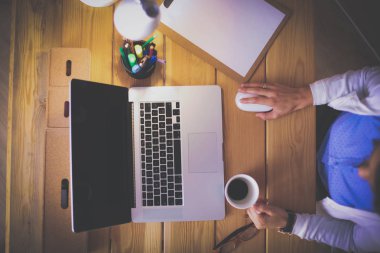 Masada oturan genç bir kadın.