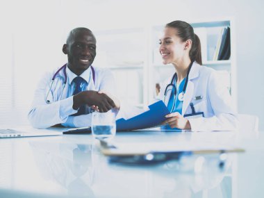 Ofiste tokalaşırken gülümseyen iki genç doktor.