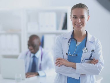 İçerde üniforması olan gülümseyen bir kadın doktor.