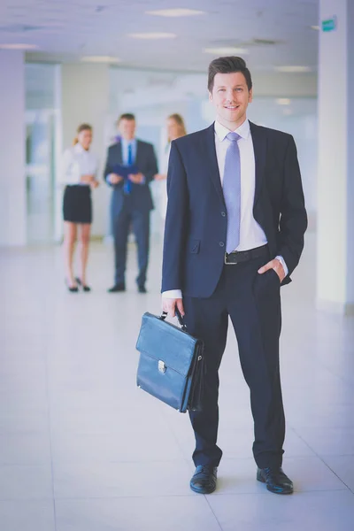 Retrato de un joven empresario en el cargo con colegas en segundo plano — Foto de Stock