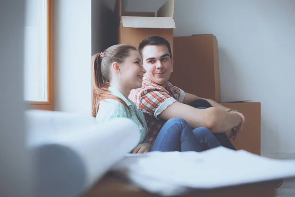 Casal em movimento em casa sentado no chão — Fotografia de Stock